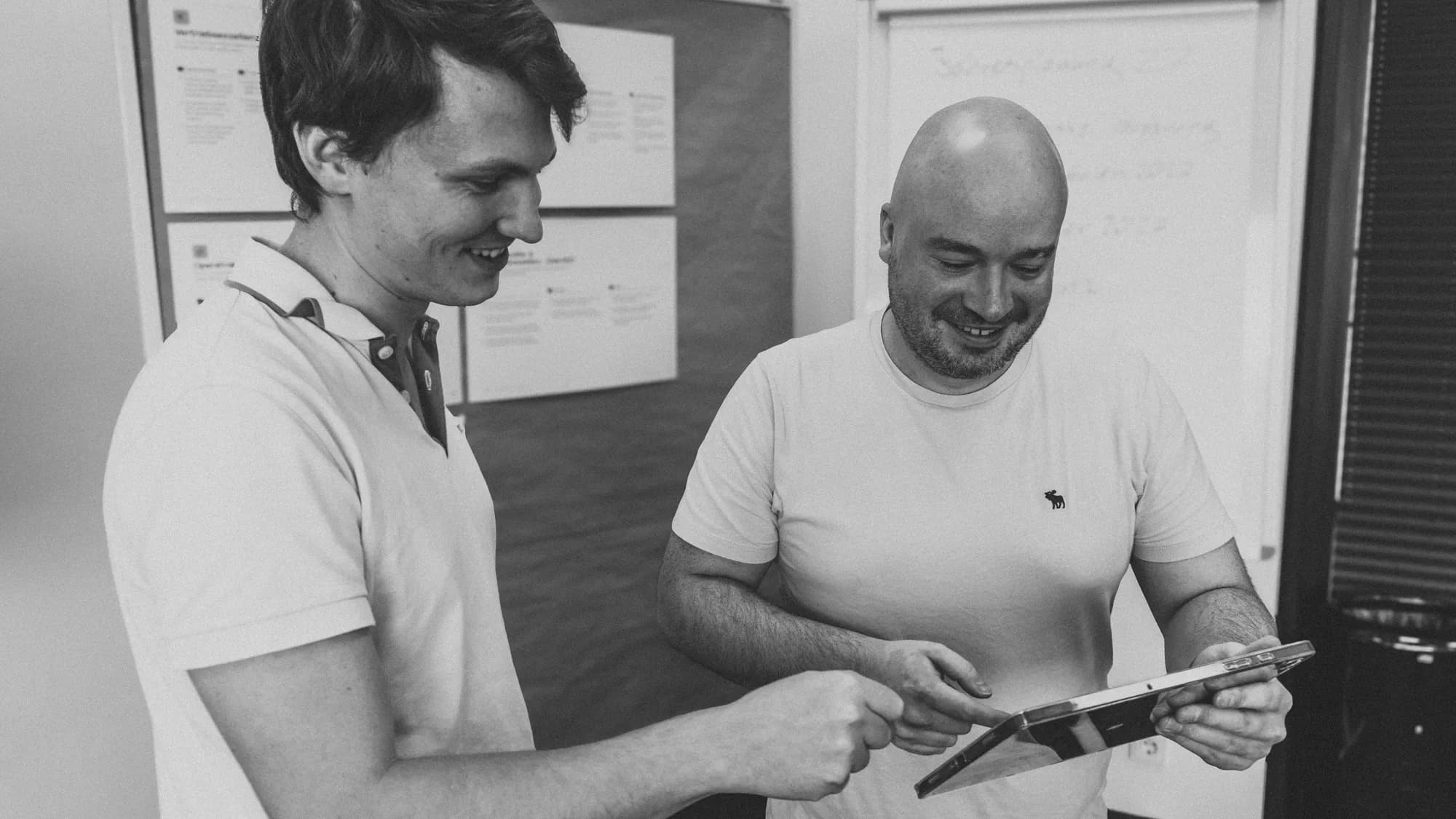 Zwei alosa-Kollegen besprechen ein Softwareprodukt auf einem Tablet